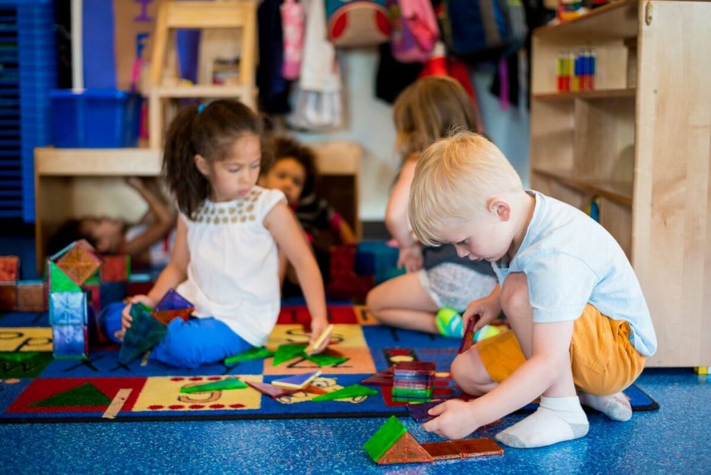 Preschool Children engaging in play-based learning with Legos at a daycare