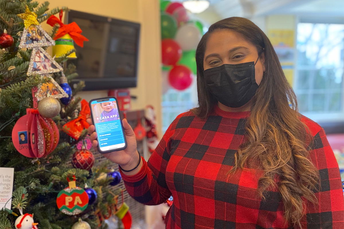 teacher at Casa holding up phone with Casa App