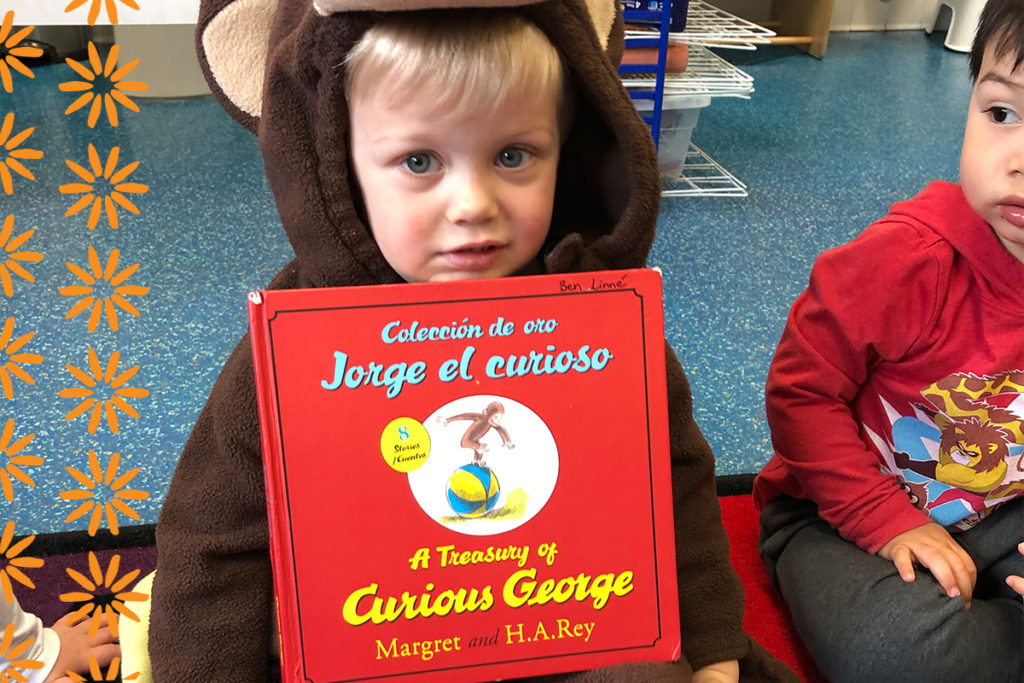 casa child holding a book in spanish to represent one of the benefits of being bilingual which is better at listening