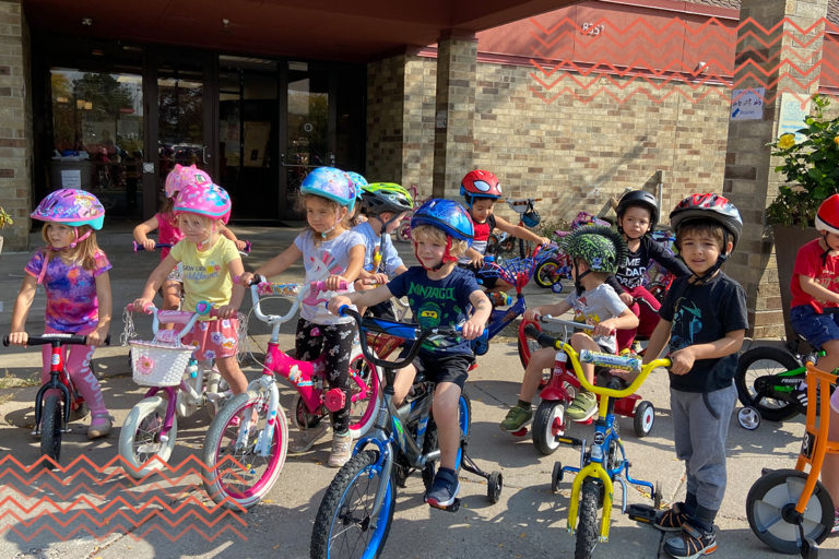 trike-a-thon week at casa, kids with bikes in front of one of our centers