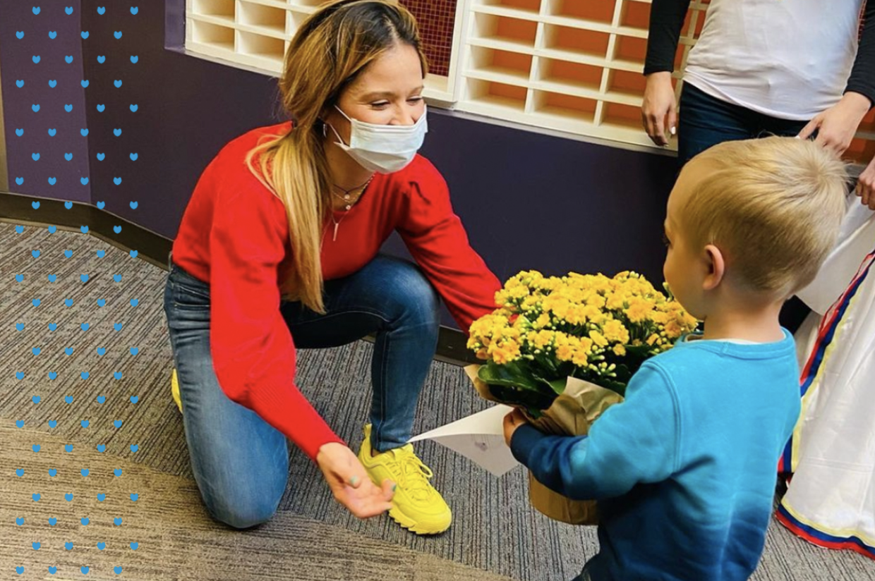 image of a student showing his thankfulness for his teacher by giving her flowers