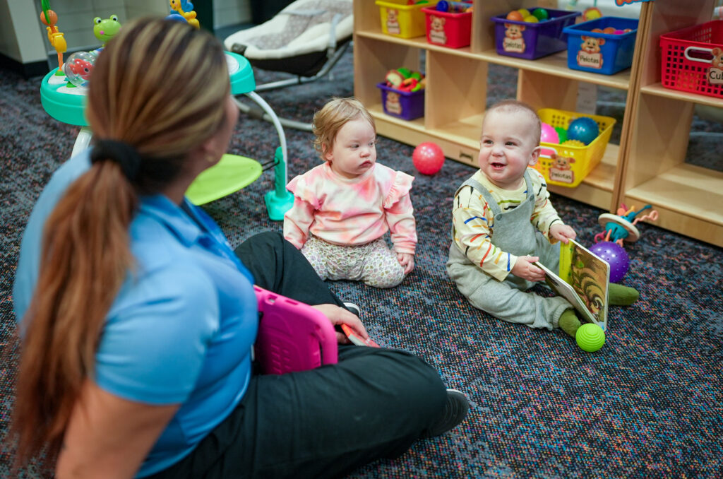 Babies playing at daycare with a caregiver